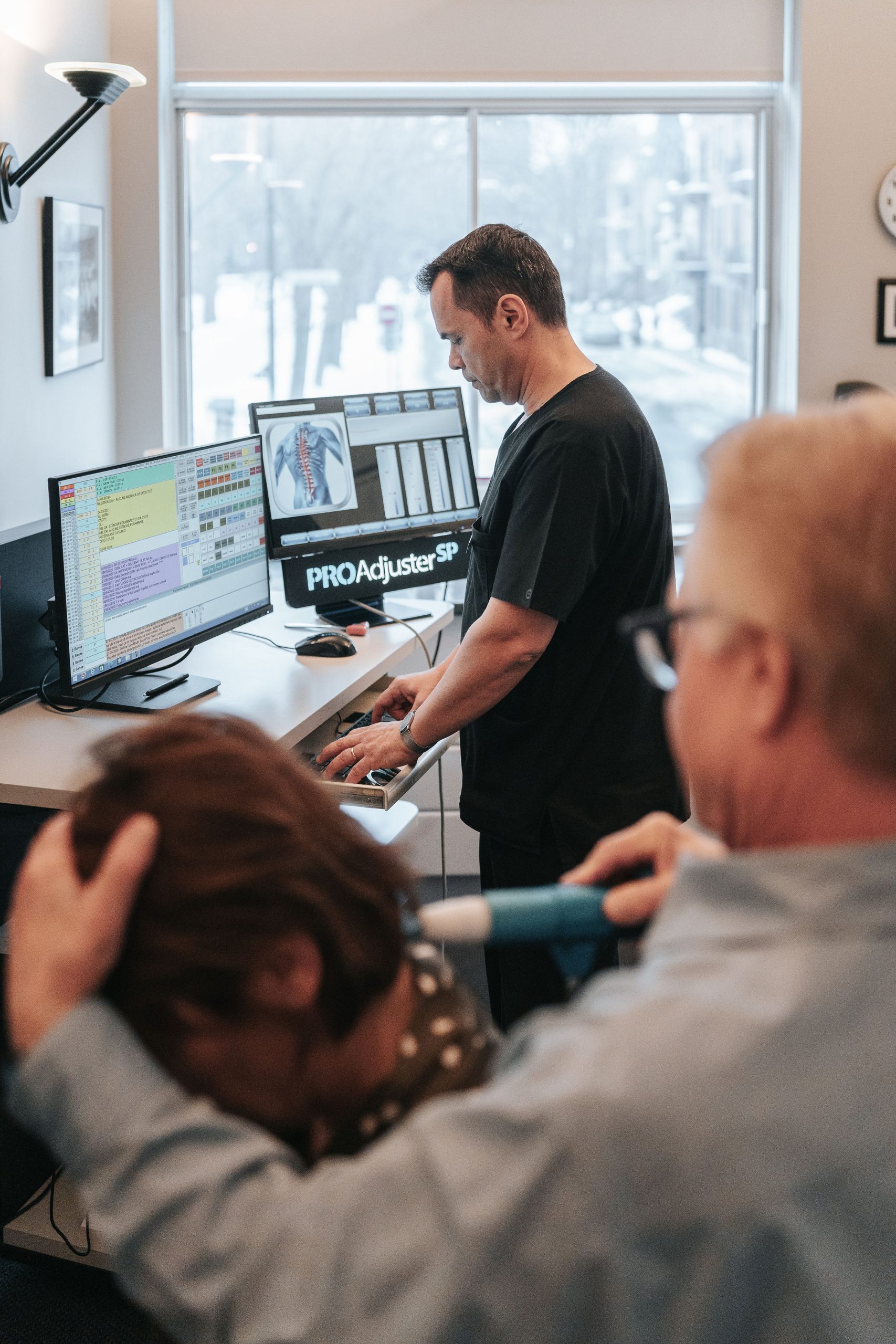 Chiropraticien utilisant un appareil à percussion contrôlé par ordinateur